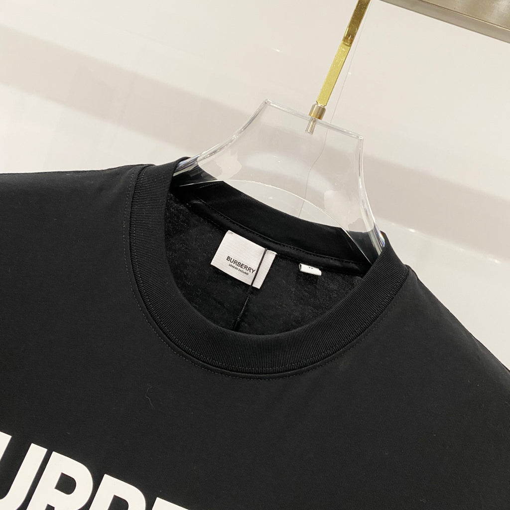 Black crew-neck T-shirt close-up with neck seam and small brand neck label