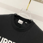 Black crew-neck T-shirt close-up with neck seam and small brand neck label