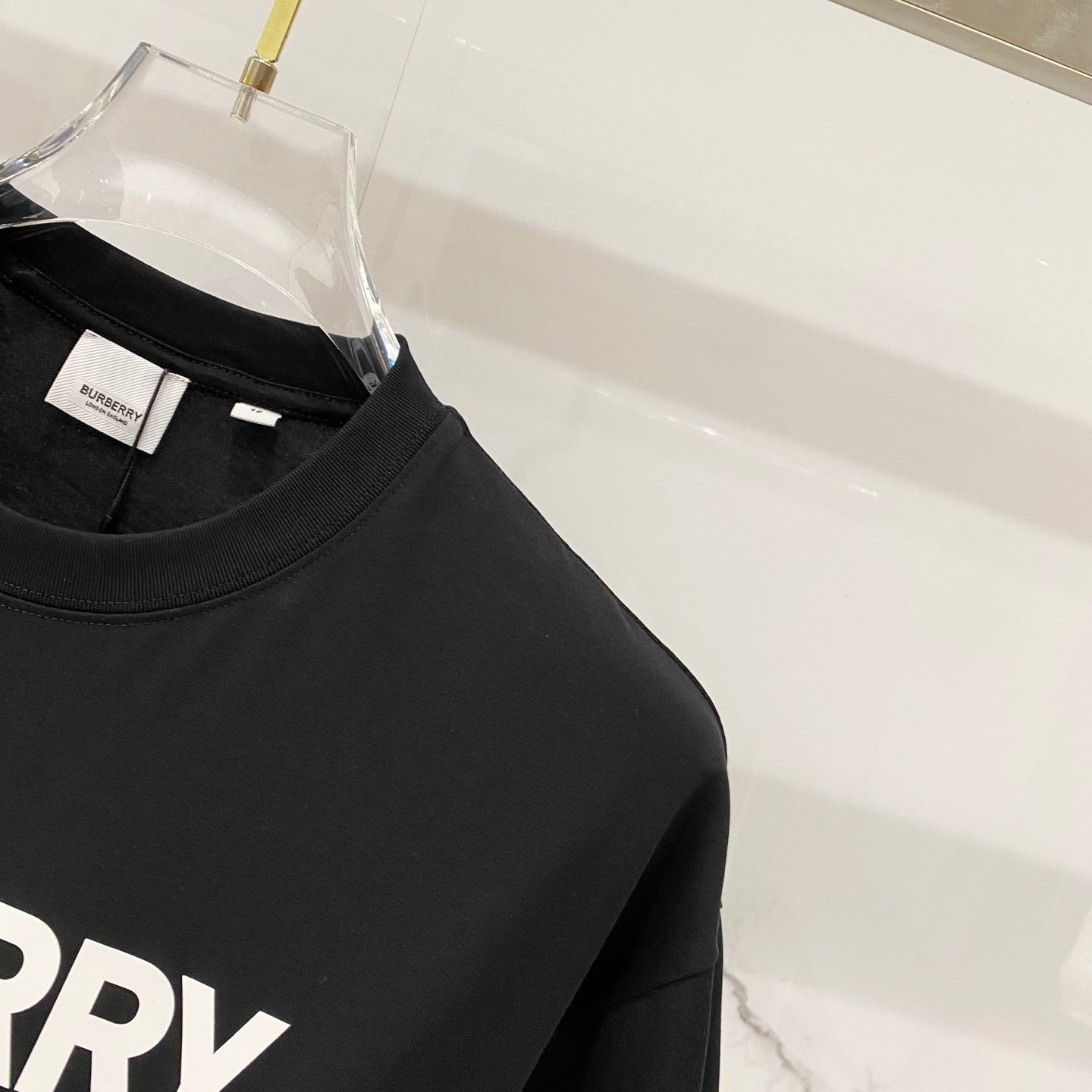 Black short-sleeve T-shirt close-up of crew collar and side seam