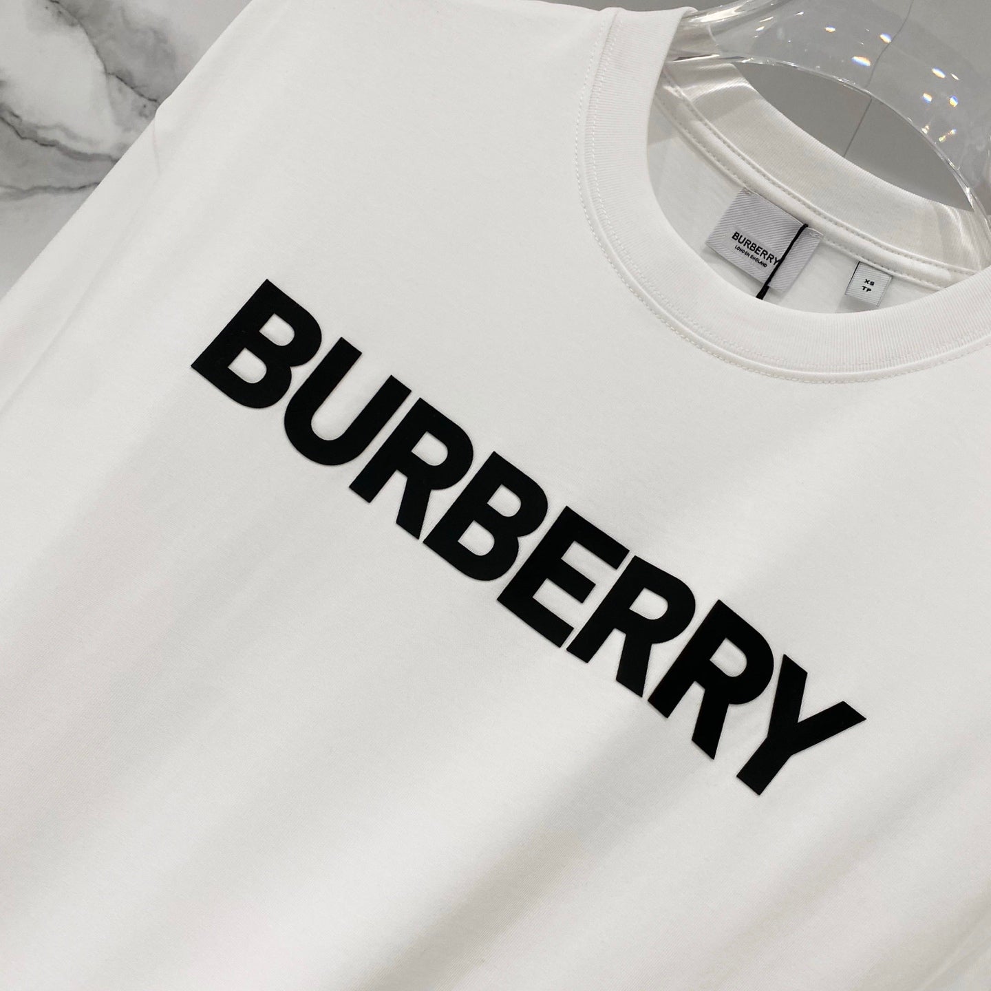 White Burberry short-sleeve T-shirt with large black BURBERRY logo, close-up
