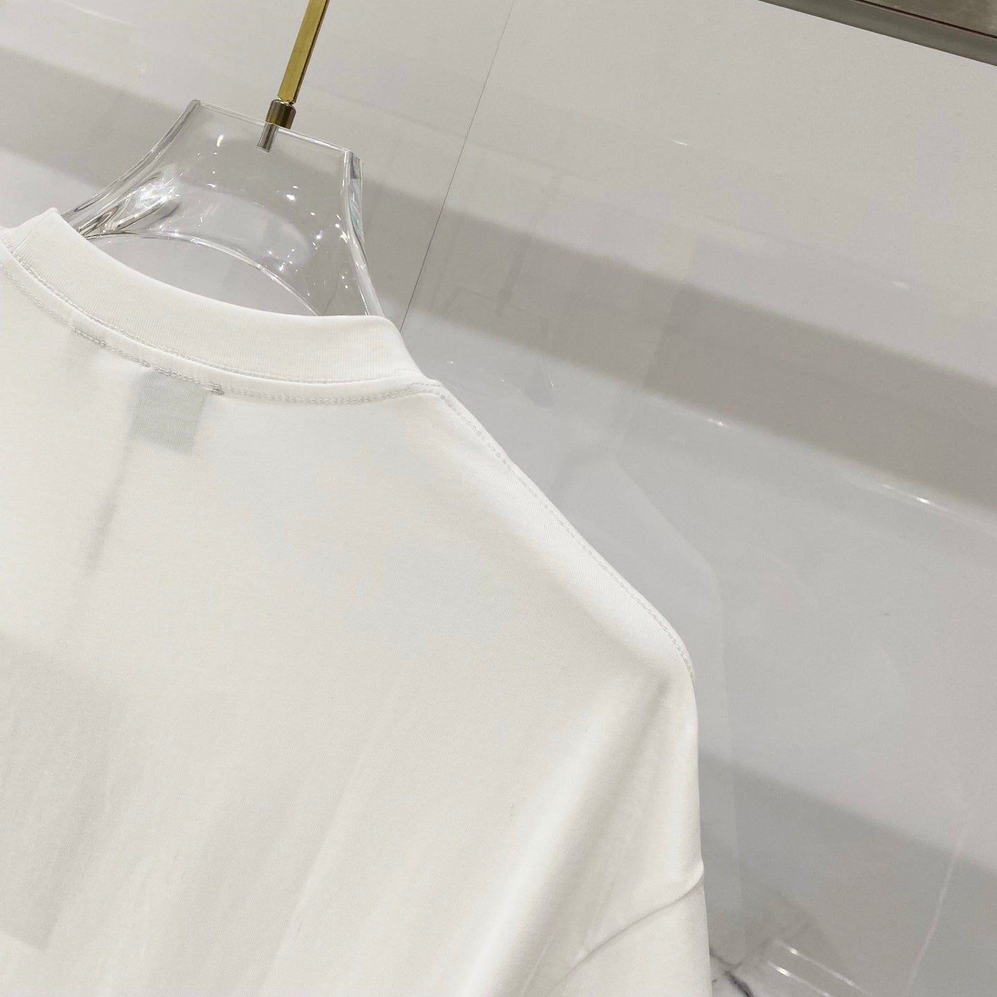 White Burberry sleeveless? No—short-sleeve T-shirt with smooth side drape, close view