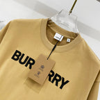 Burberry tan T-shirt close-up with partial black "BURRY" logo print