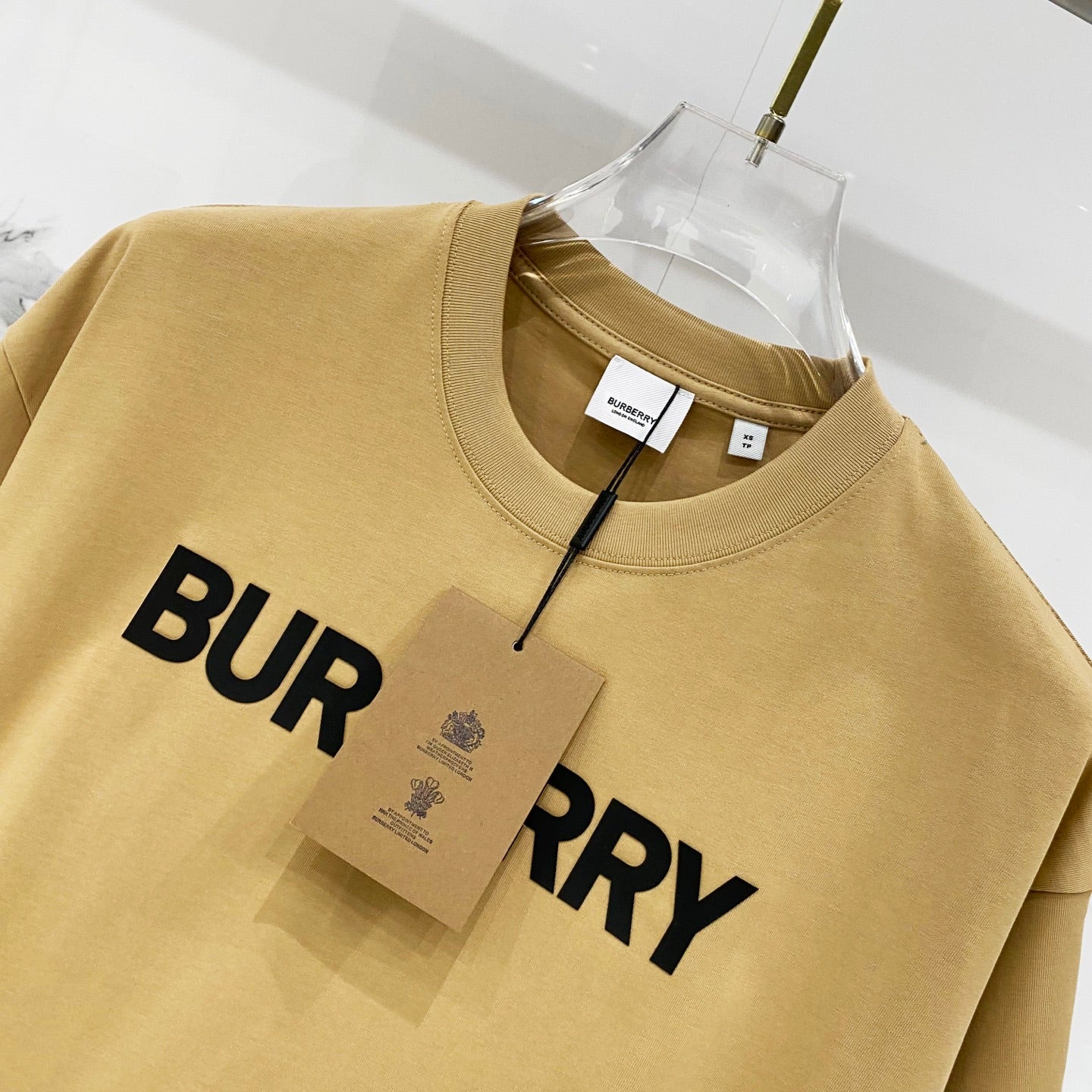 Burberry tan T-shirt close-up with partial black "BURRY" logo print