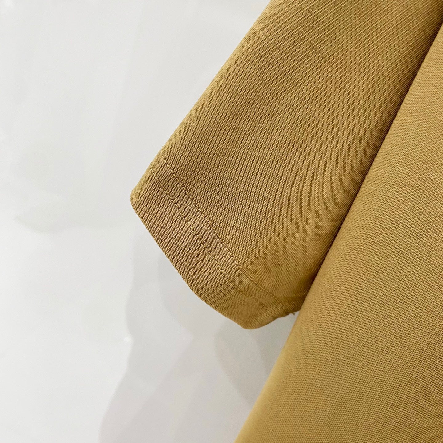 Burberry tan T-shirt sleeve hem close-up with stitched edge