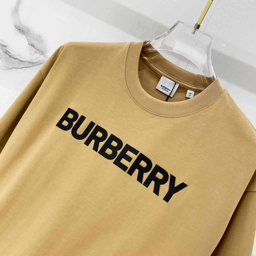 Burberry tan T-shirt close-up with large black "BURBERRY" logo