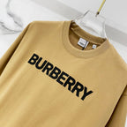 Burberry tan T-shirt close-up with large black "BURBERRY" logo