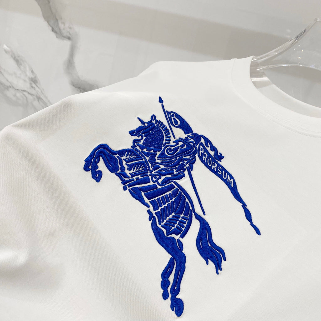 White T-shirt with large blue horse rider crest graphic on the front.