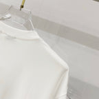White T-shirt side view with stitched sleeve seam and curved hem.