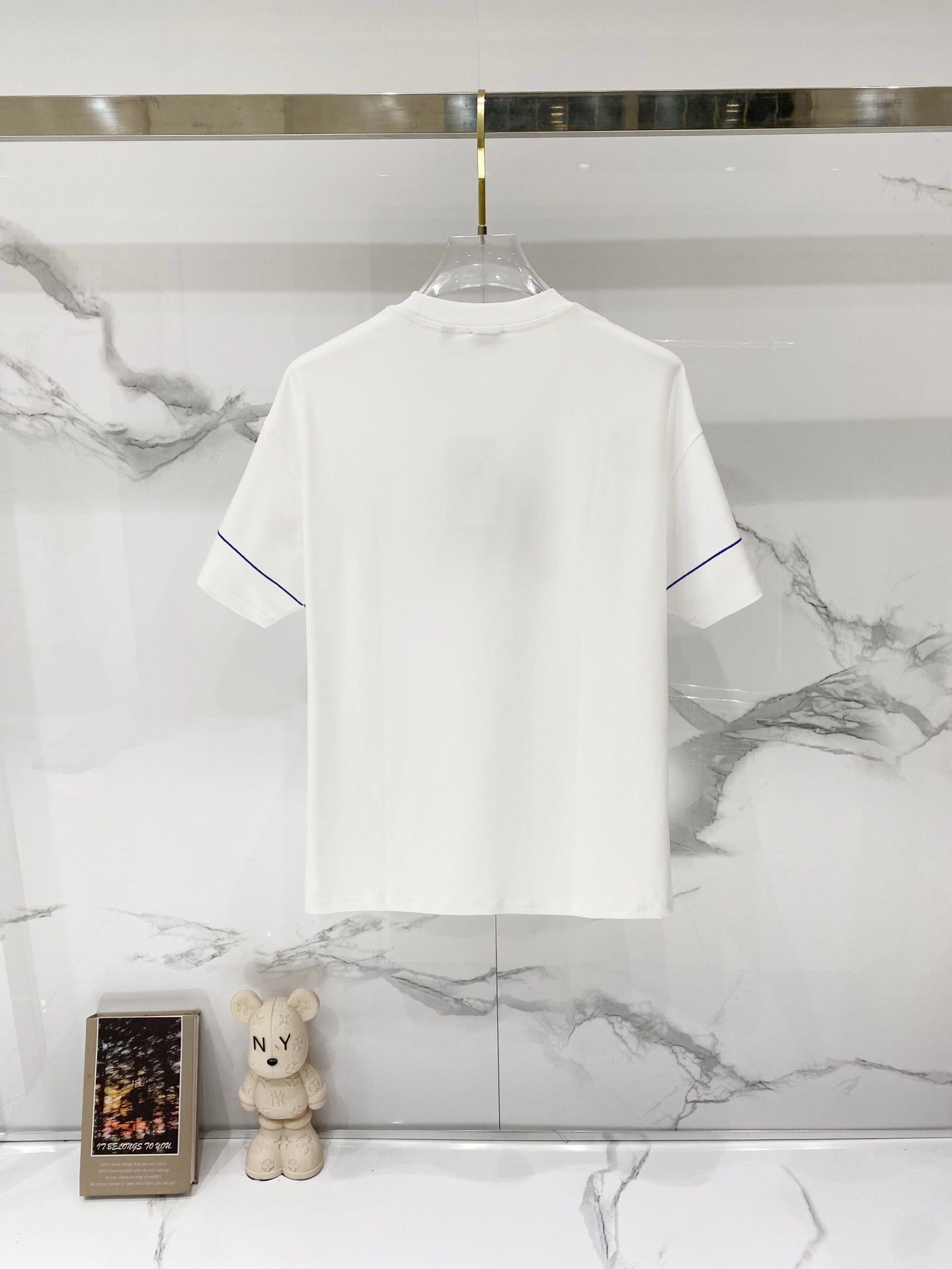 White short-sleeve T-shirt on hanger, front view plain.