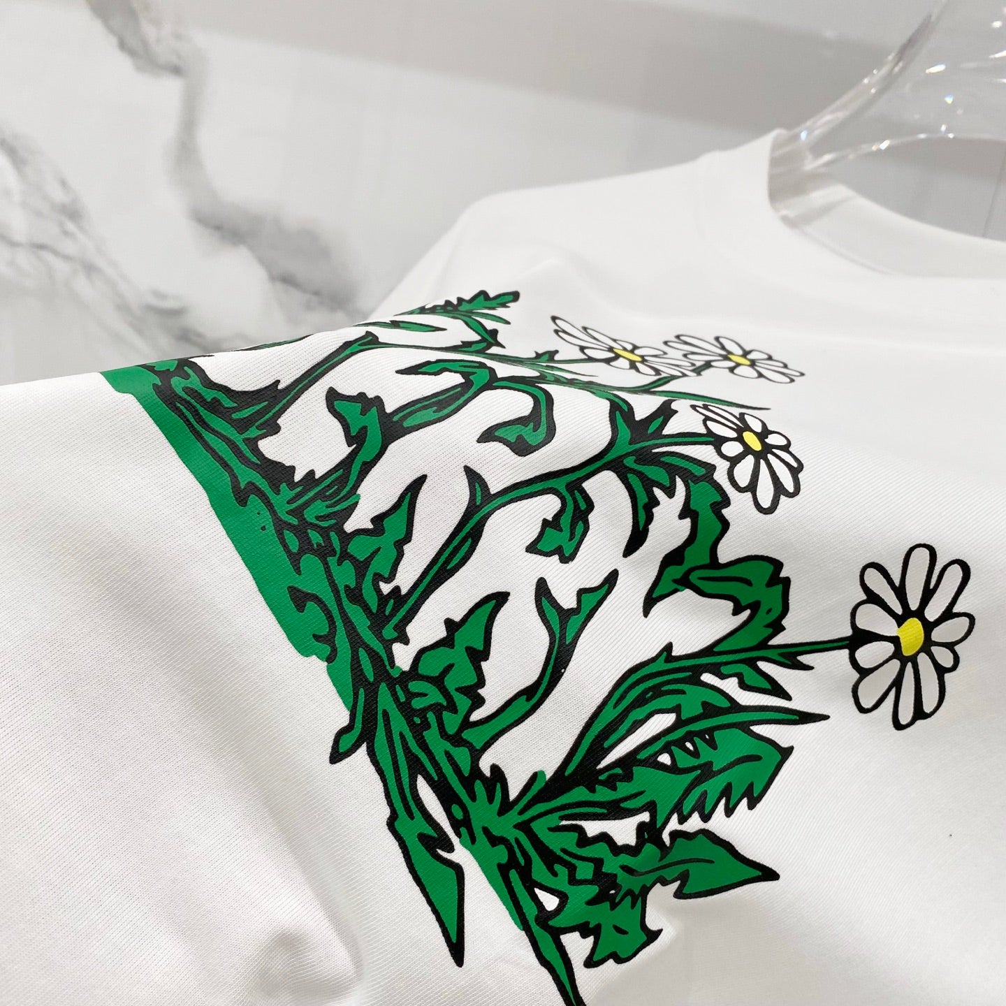 White short-sleeve T-shirt with large green foliage and white flower print