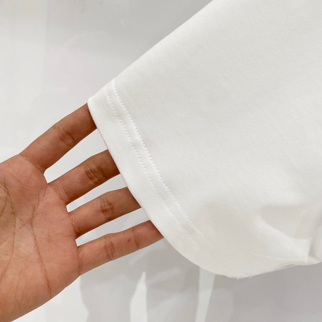 White short-sleeve T-shirt sleeve hem close-up held in hand