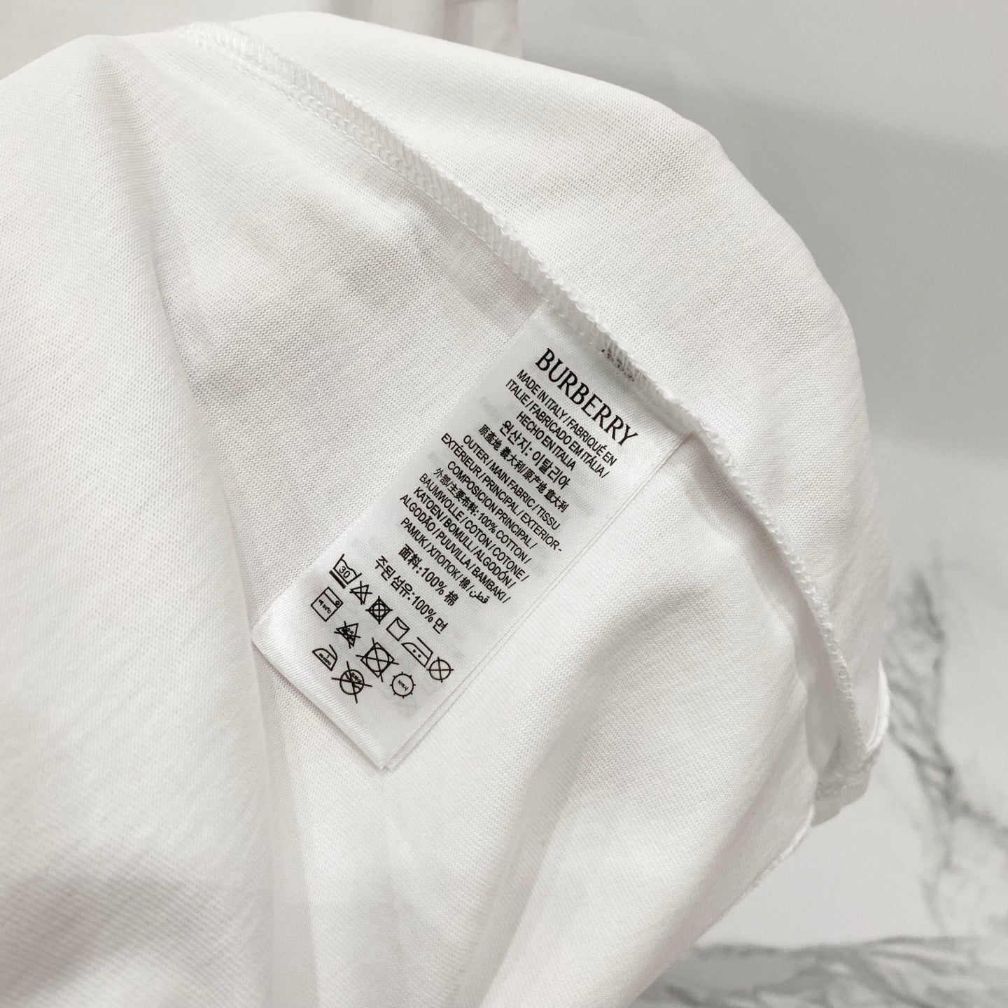 White short-sleeve T-shirt care label with Burberry branding on inner tag