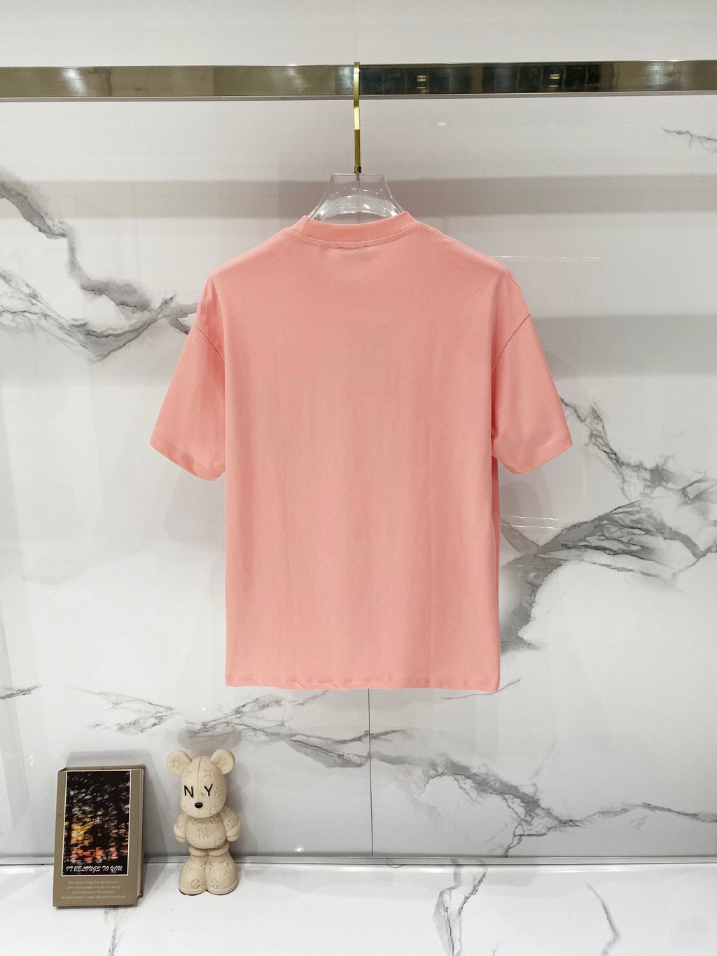 Pink Burberry T-shirt with plain back view on a clear hanger.