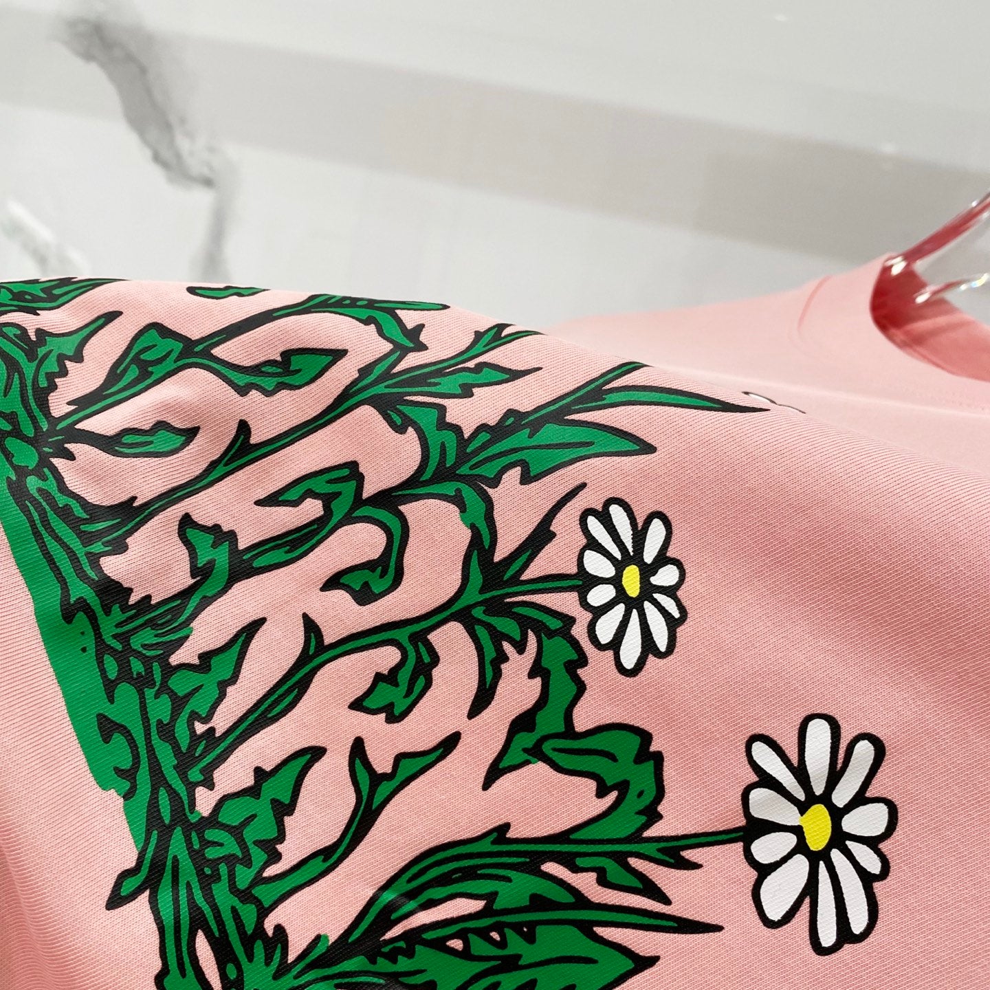 Pink Burberry T-shirt with green foliage and white daisy print detail.