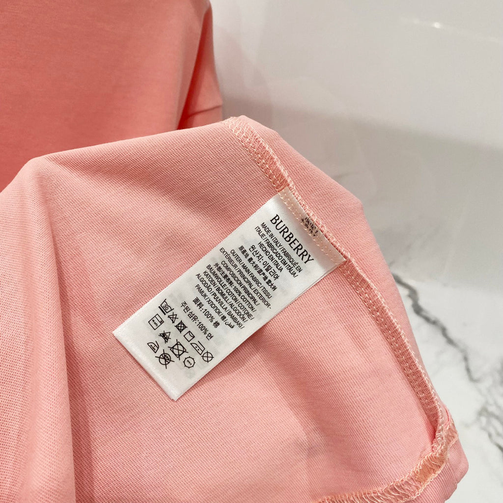 Pink Burberry T-shirt care label on the sleeve edge.