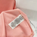 Pink Burberry T-shirt care label on the sleeve edge.