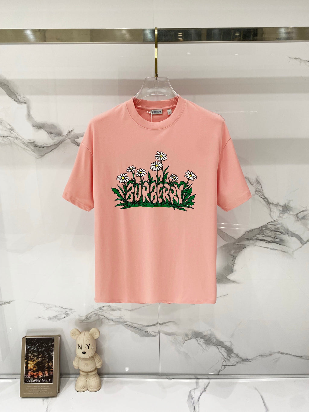 Pink Burberry T-shirt with floral logo graphic on the front.
