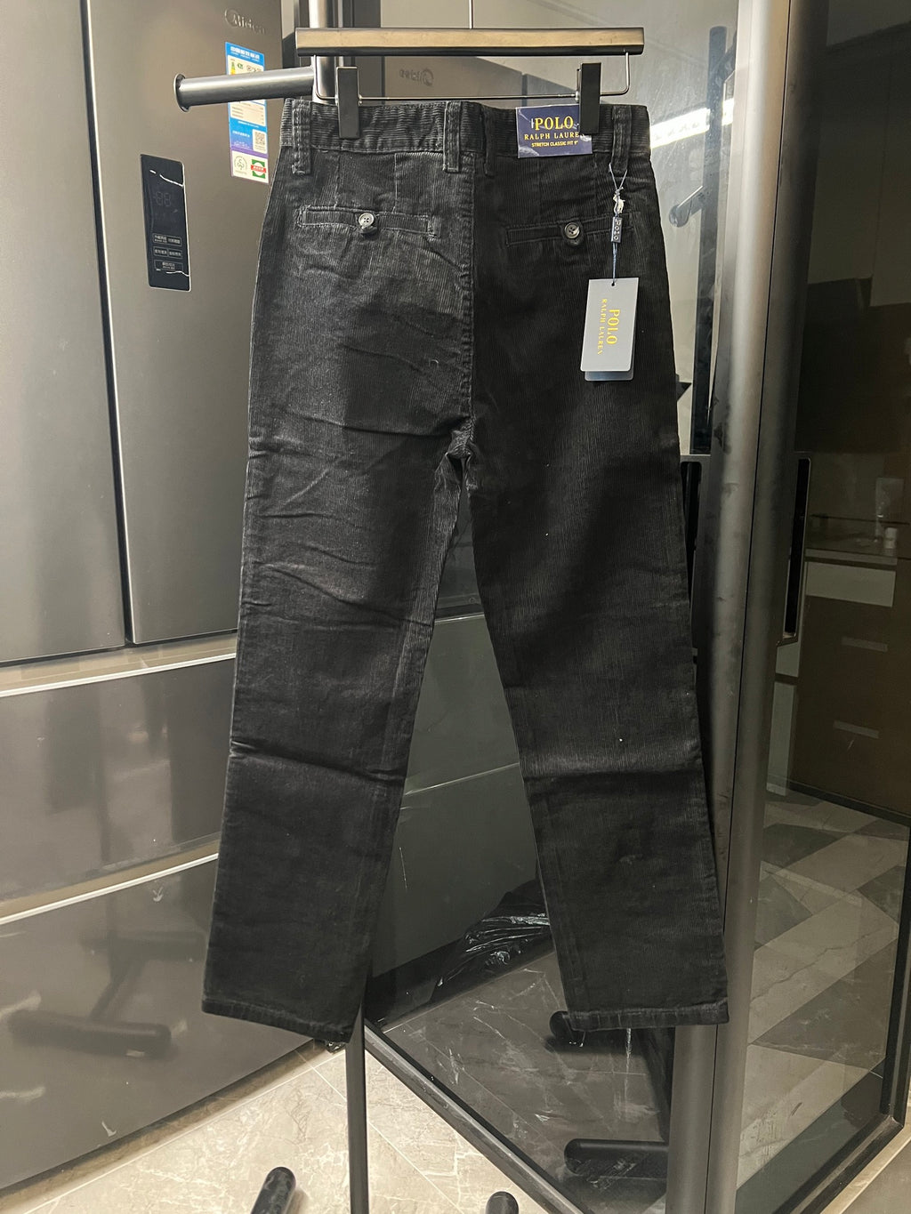 Black corduroy jeans front view with button closure and side pockets