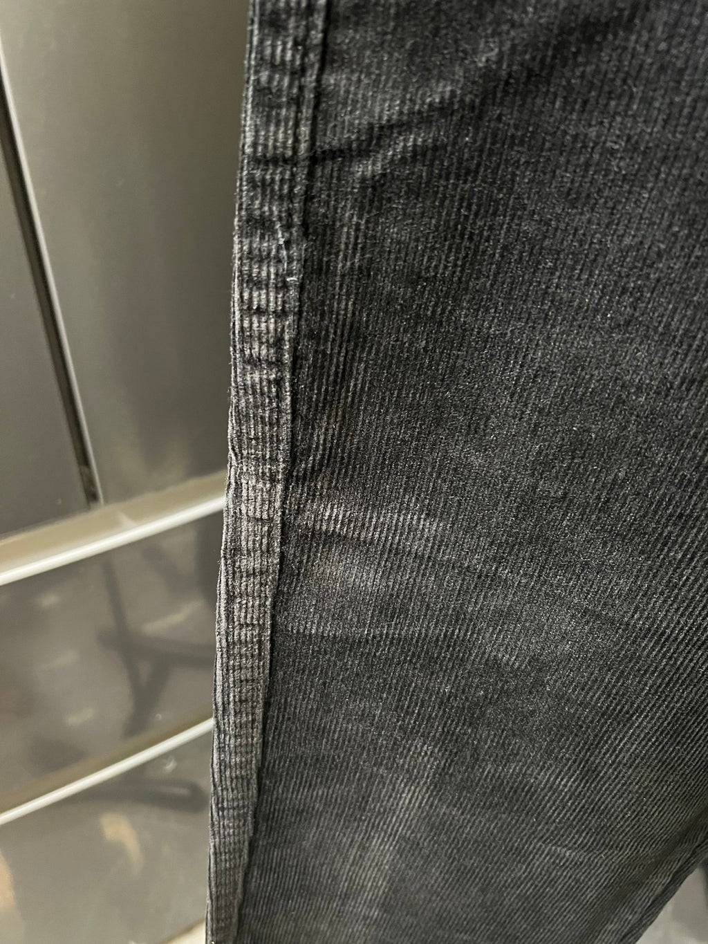Dark corduroy fabric panel with fine vertical ridges