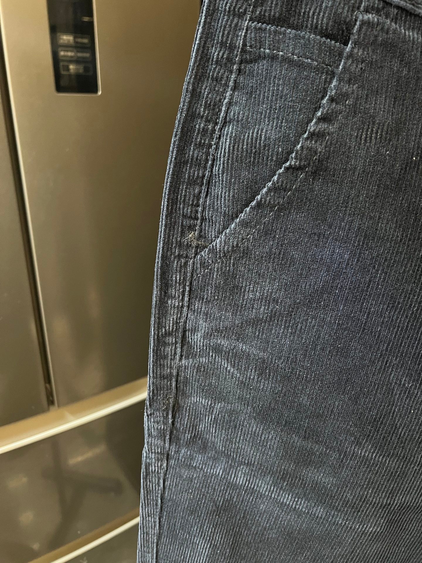 Close-up of denim jeans pocket seam and textured fabric