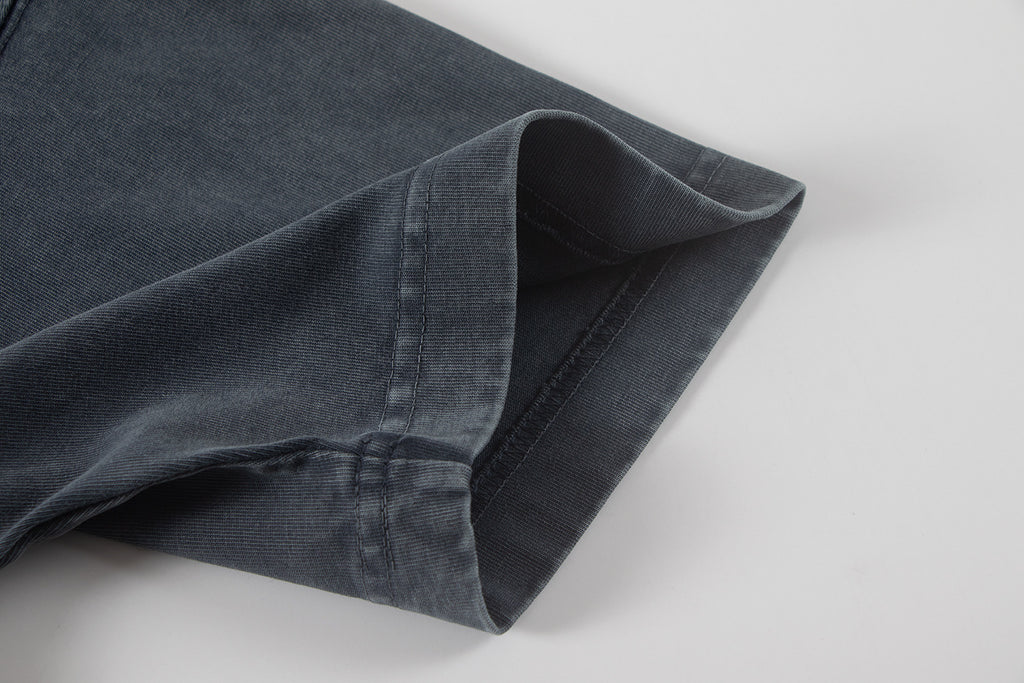 Dark T-shirt short sleeve cuff with visible seam and hem stitching.