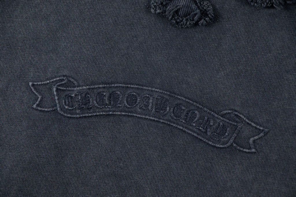 Close-up of dark embroidered text graphic on T-shirt back yoke area.