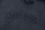 Close-up of dark embroidered text graphic on T-shirt back yoke area.