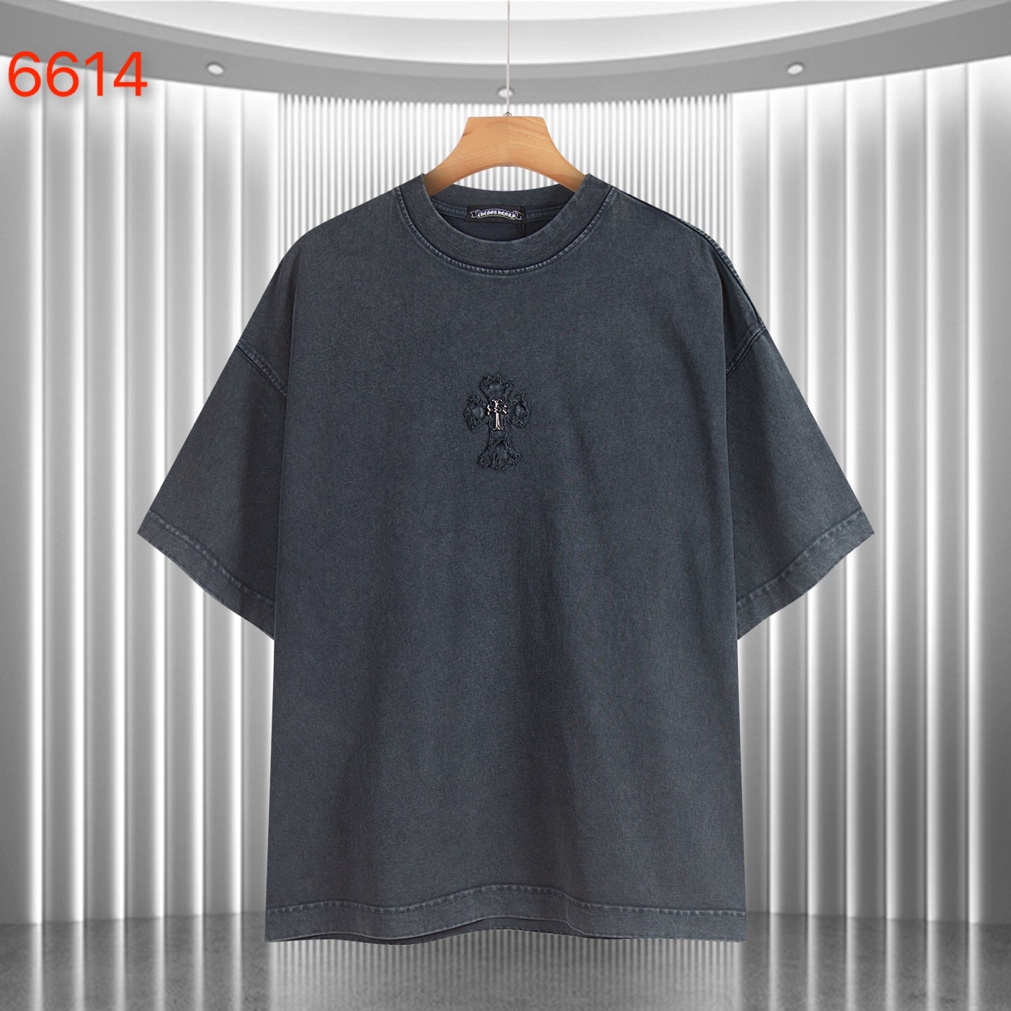 Dark T-shirt with small front embroidered crest and wide short sleeves.