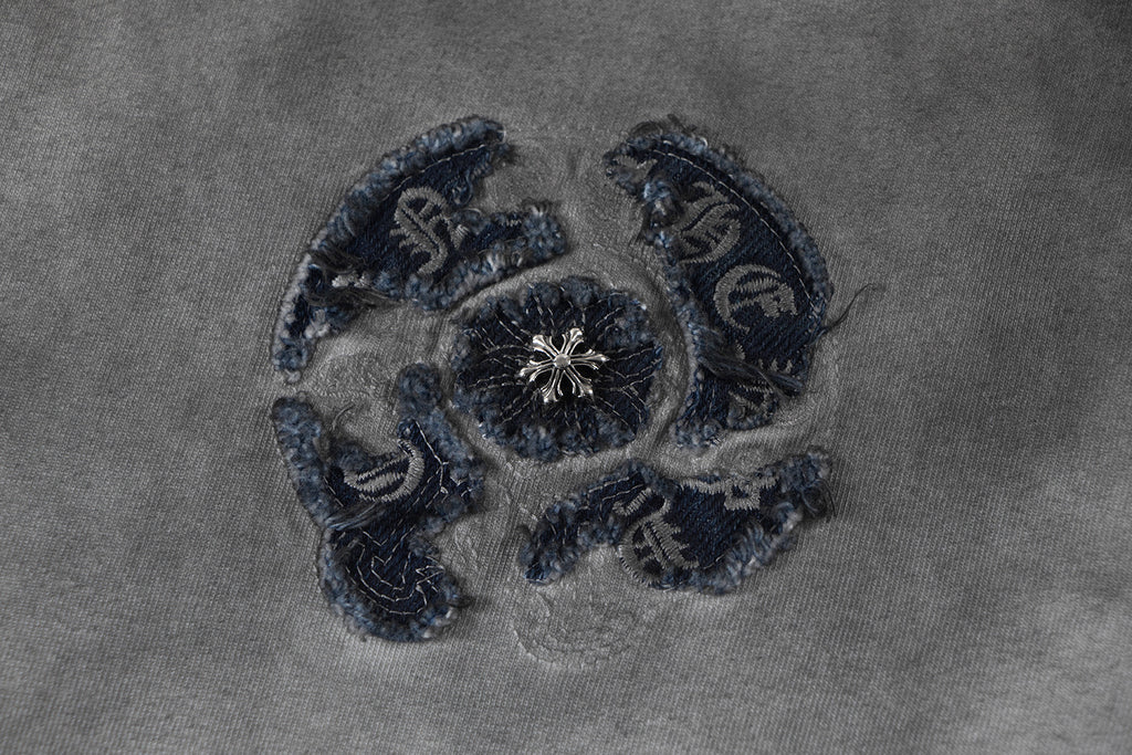 Embroidered emblem detail on T-shirt fabric in navy thread