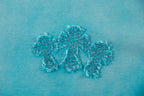 Turquoise T-shirt with glittery floral appliqué motif on front