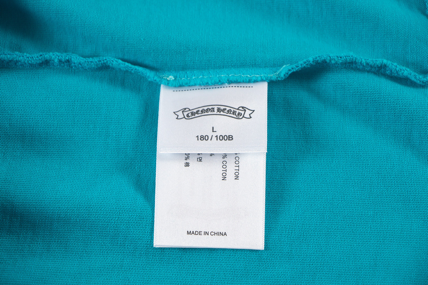 Turquoise T-shirt with size label 180/100B and Made in China tag