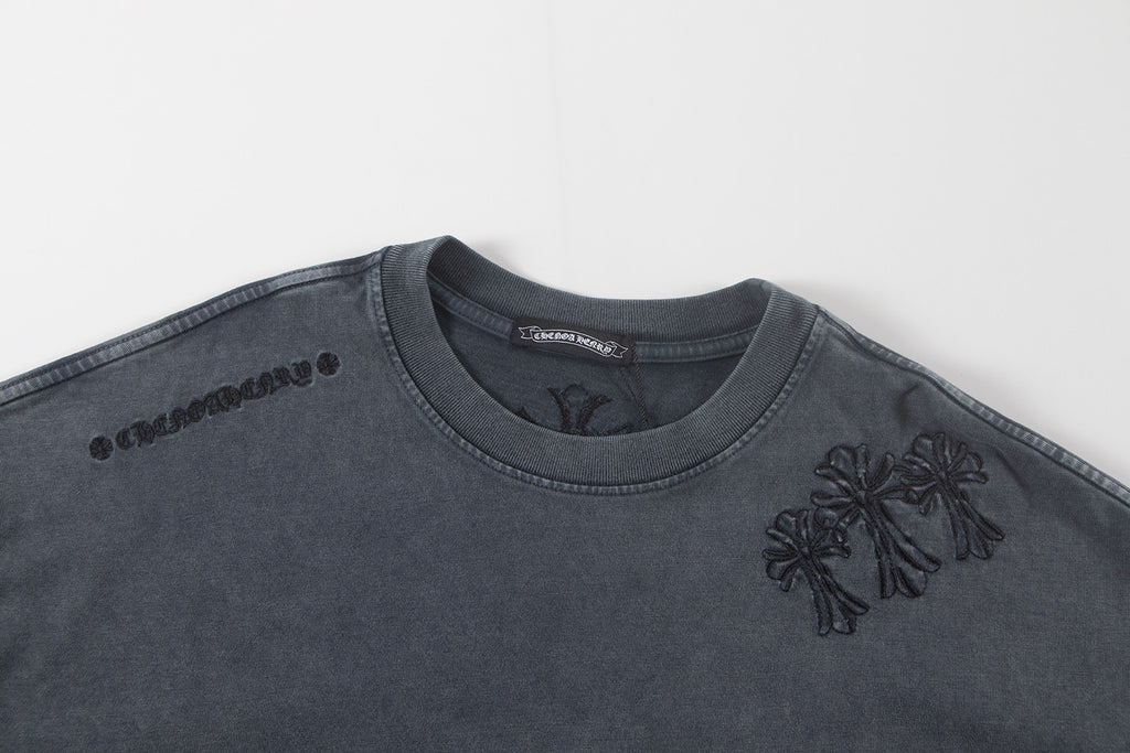 Dark gray graphic T-shirt with chest emblem and small flower detail