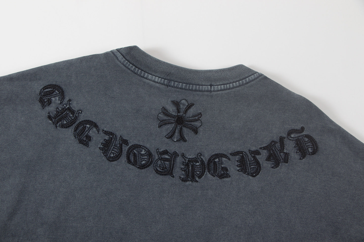 Back of dark gray graphic T-shirt with embroidered lettering and flower icons