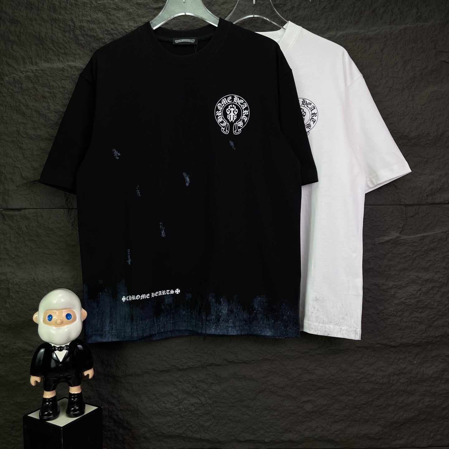 Black and white short-sleeve graphic T-shirts, each with circular chest logo and distressing