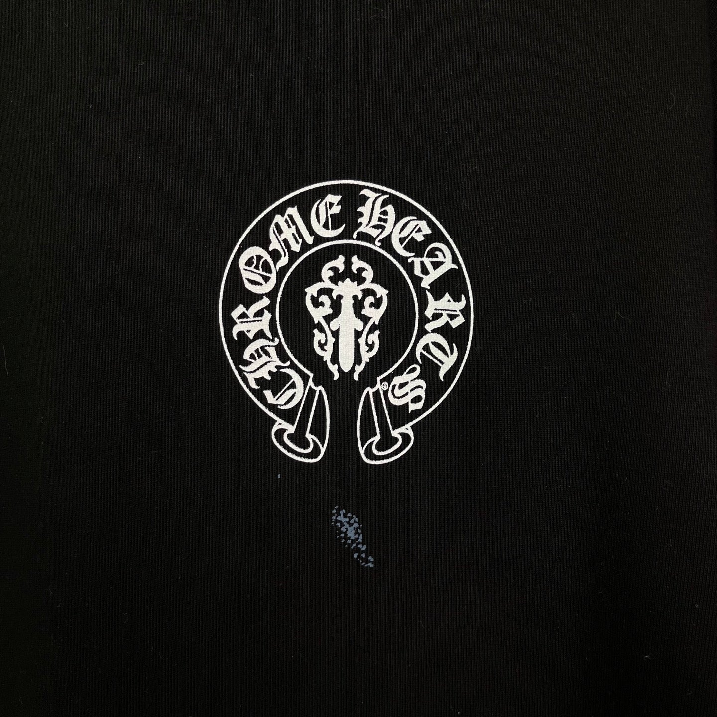 Chrome short-sleeve T-shirt logo detail, white circular emblem on black fabric