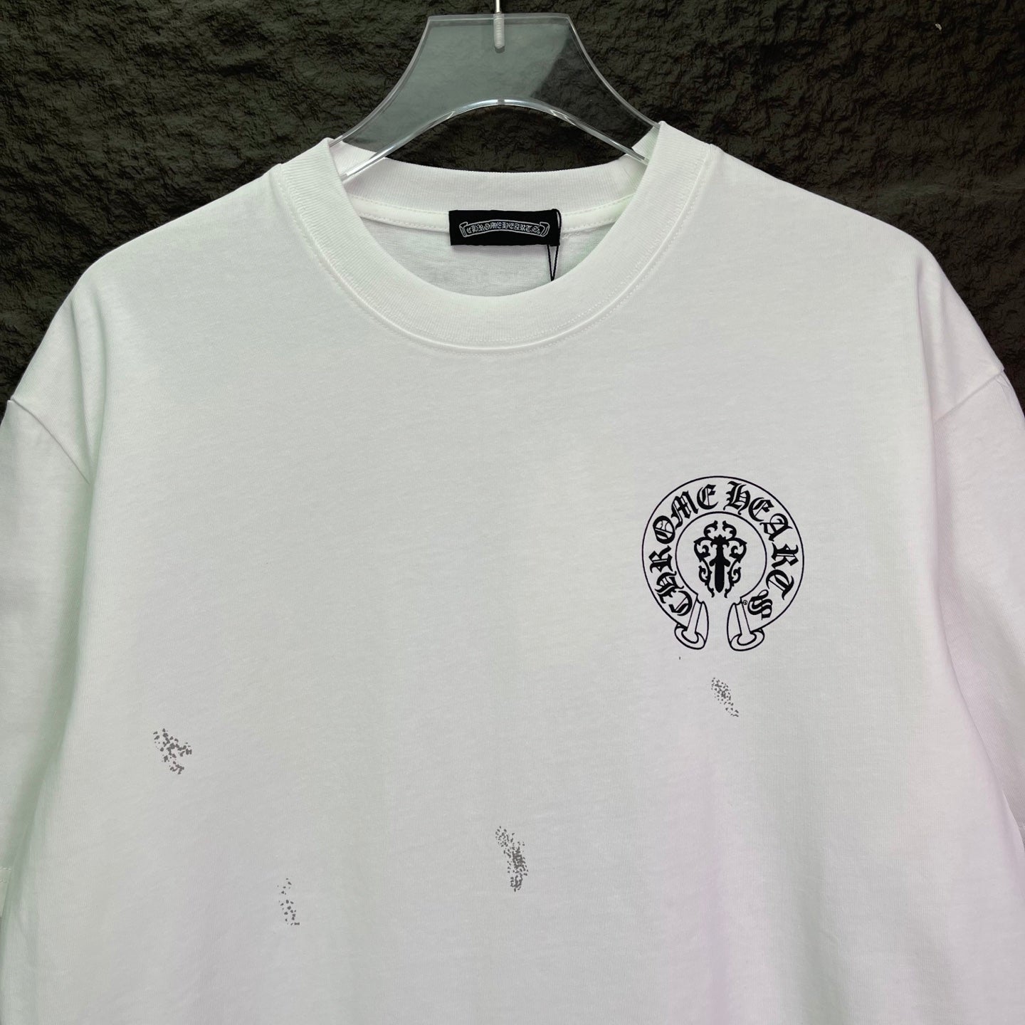 White short-sleeve graphic T-shirt with small circular chest logo