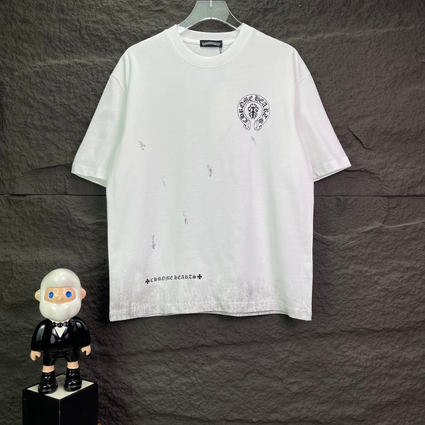 White short-sleeve graphic T-shirt with small chest logo and distressed print marks