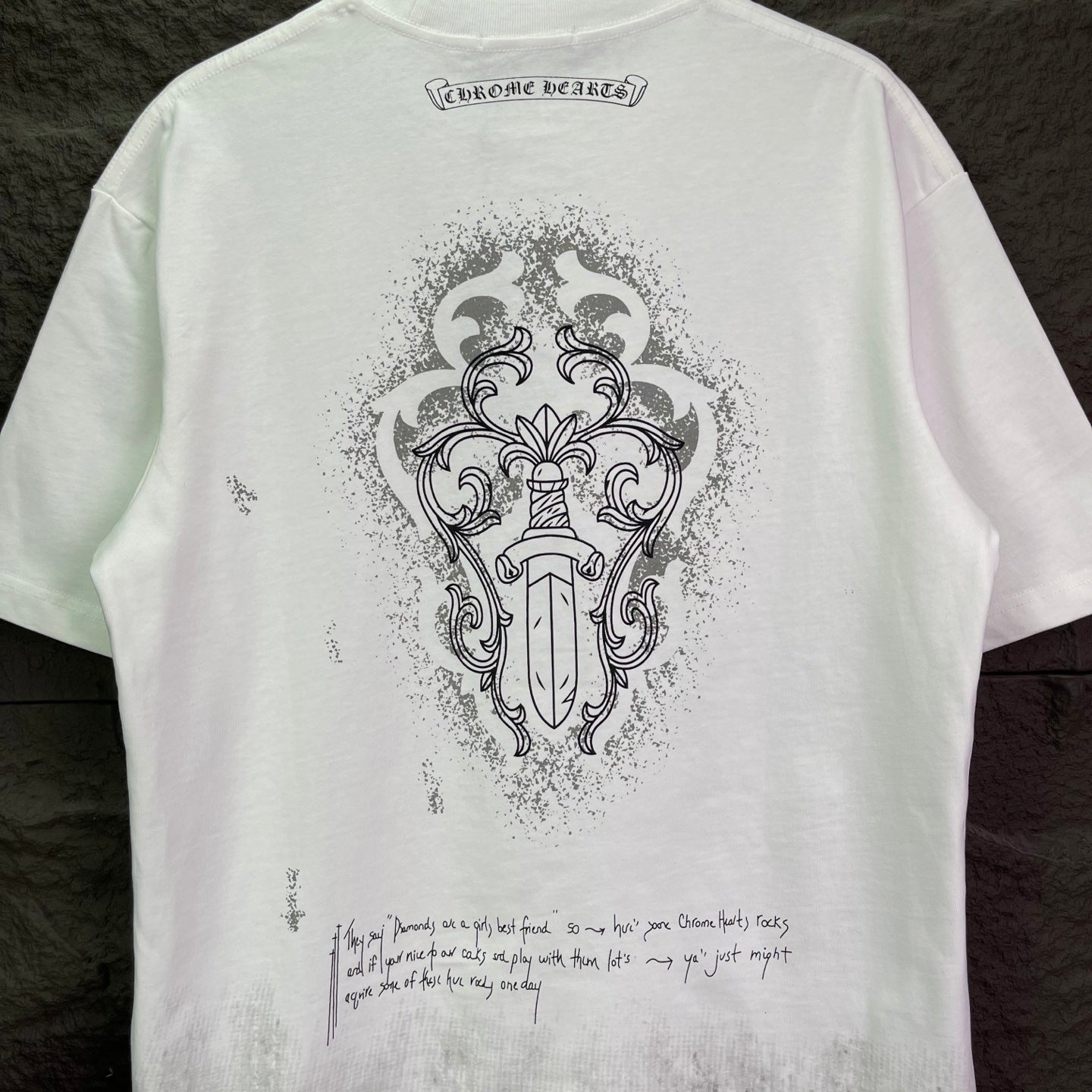 White short-sleeve T-shirt back with ornate crest graphic and small caption text