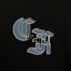 Black T-shirt close-up with embroidered light-blue logo detail