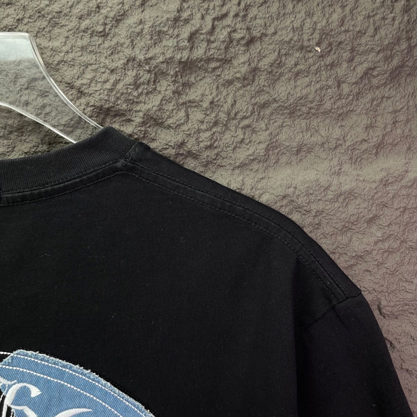 Black T-shirt close-up of back neckline and shoulder seam