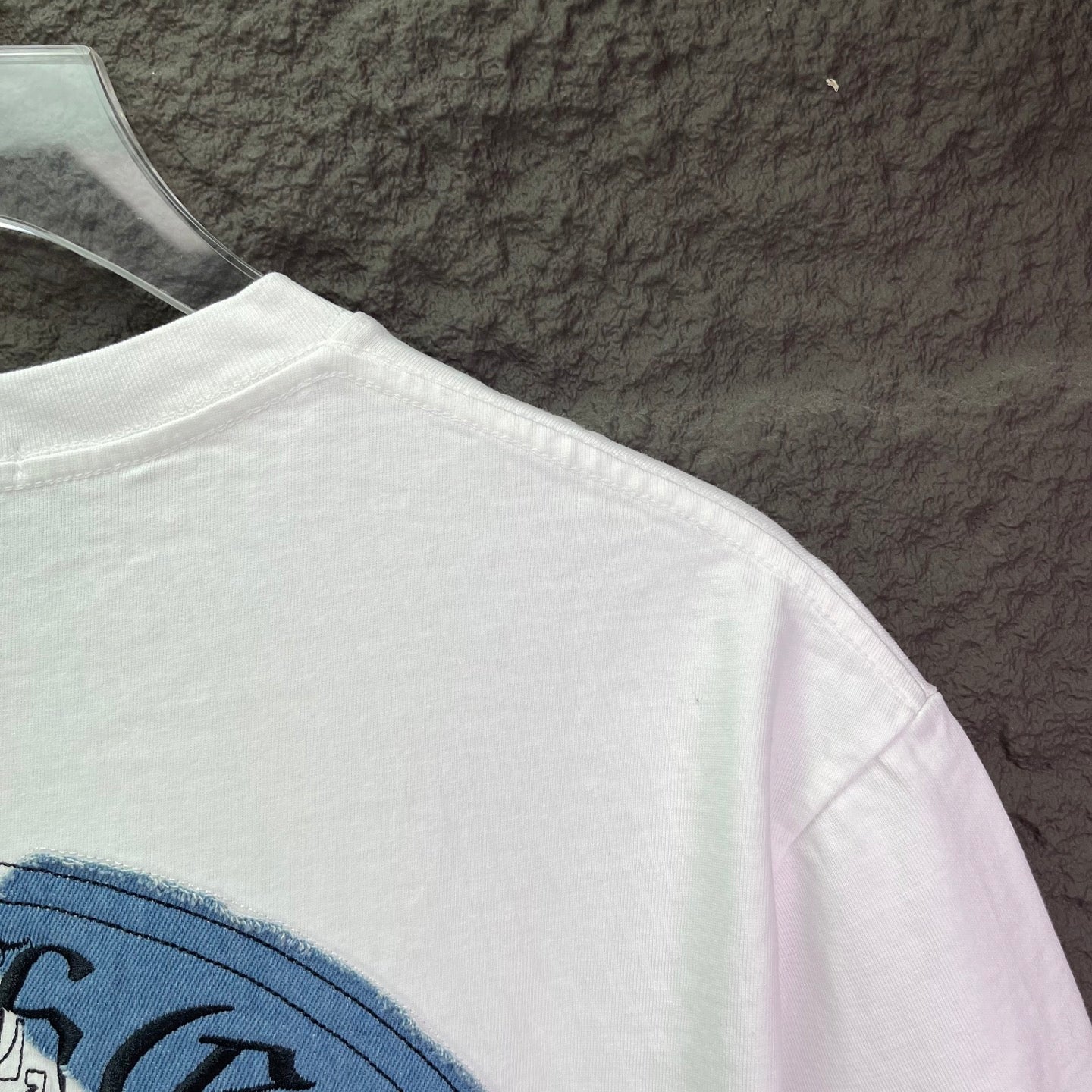 White short-sleeve T-shirt with plain fabric and curved back hem on hanger