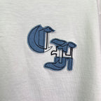 Close-up of white T-shirt with blue icon-style chest graphic