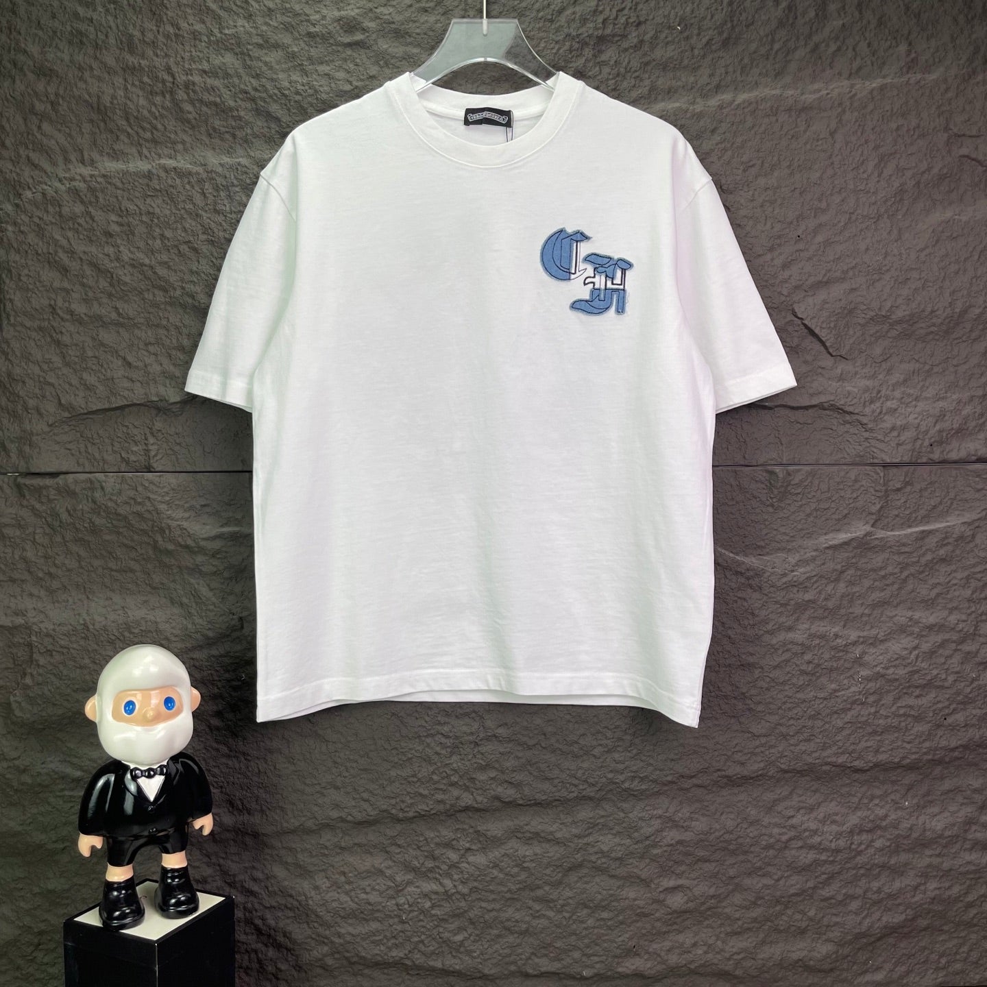 White short-sleeve T-shirt with small blue graphic logo on chest