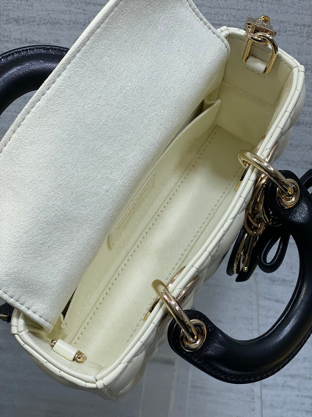 Quilted handbag interior pocket with light lining and gold-tone rings at side