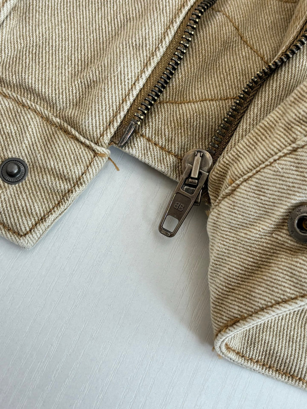 Beige jacket zipper and stitched seams close-up