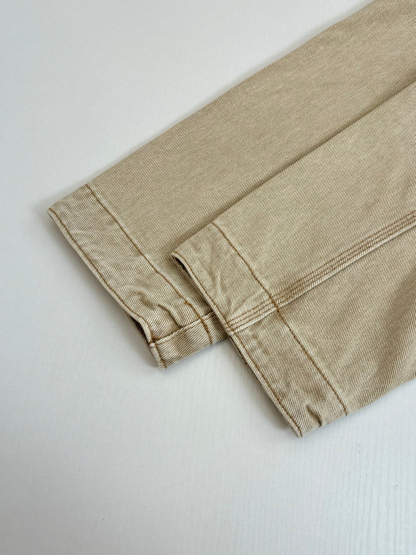 Beige long-sleeve jacket cuff and hem seam detail
