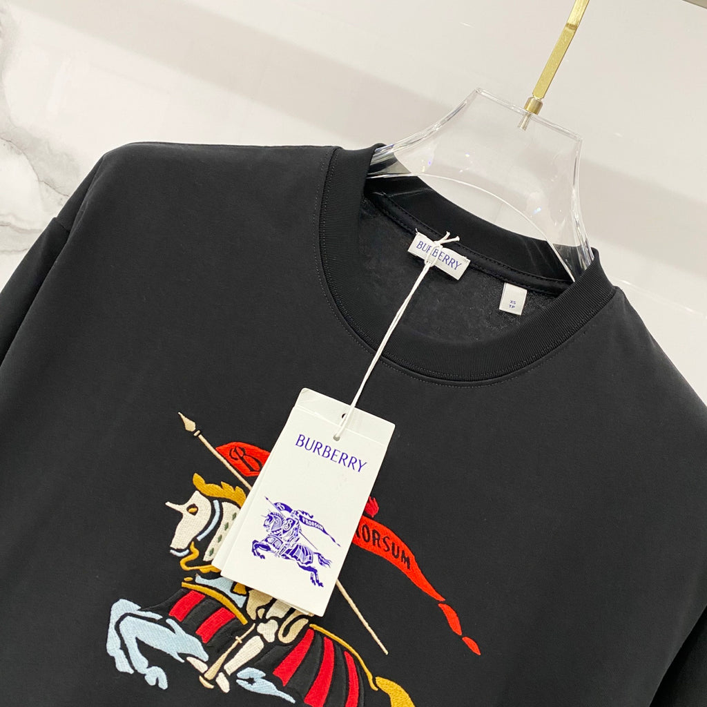 Black T-shirt with colorful horse rider graphic and hanging product tags