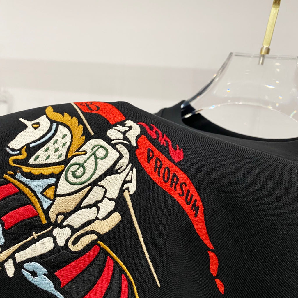 Black T-shirt close-up of colorful horse rider graphic and red text