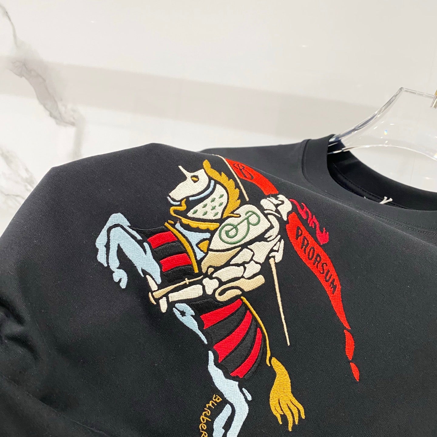 Black T-shirt close-up showing large colorful horse rider graphic on chest