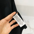 Black T-shirt care label on inside cuff with sizing and washing icons